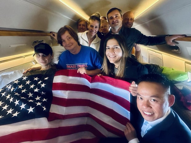 Robert Gilman, left, is seen on a plane after his release from Russia. 