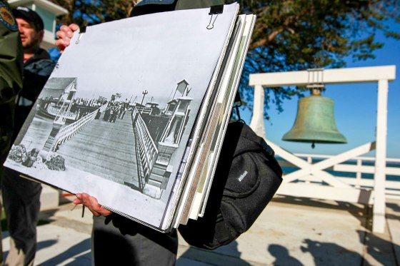 A California State Park worker holds a photo of the old pier.
