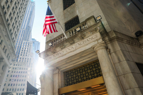 The New York Stock Exchange building exterior, an American flag is posted atop