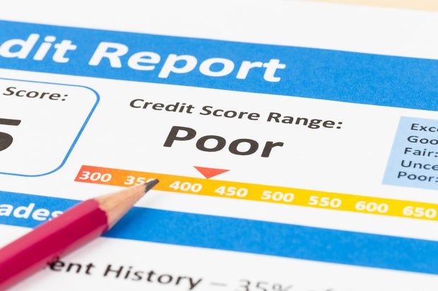 Poor credit score report with pen and calculator 