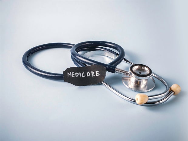 Stethoscope Near Piece of Paper with Medicare Text on Blue Background: A Concept for US Government Health Insurance and Senior Healthcare 
