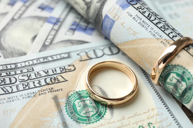 Gold wedding rings and dollar banknotes, closeup 